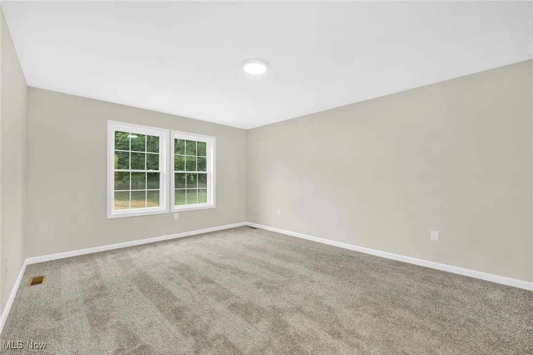 Carpeted empty room with baseboards