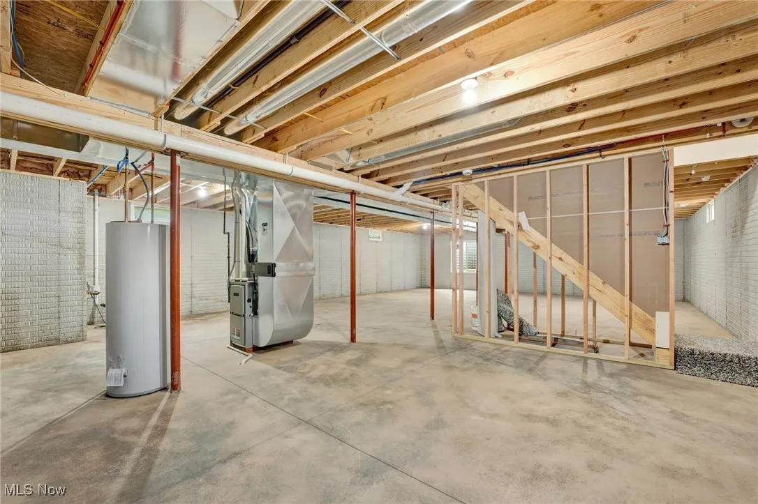 Unfinished below grade area with heating unit and gas water heater