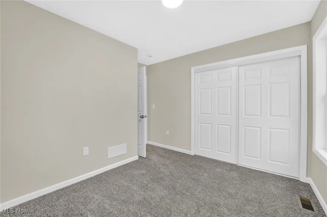 Unfurnished bedroom featuring carpet floors and a closet