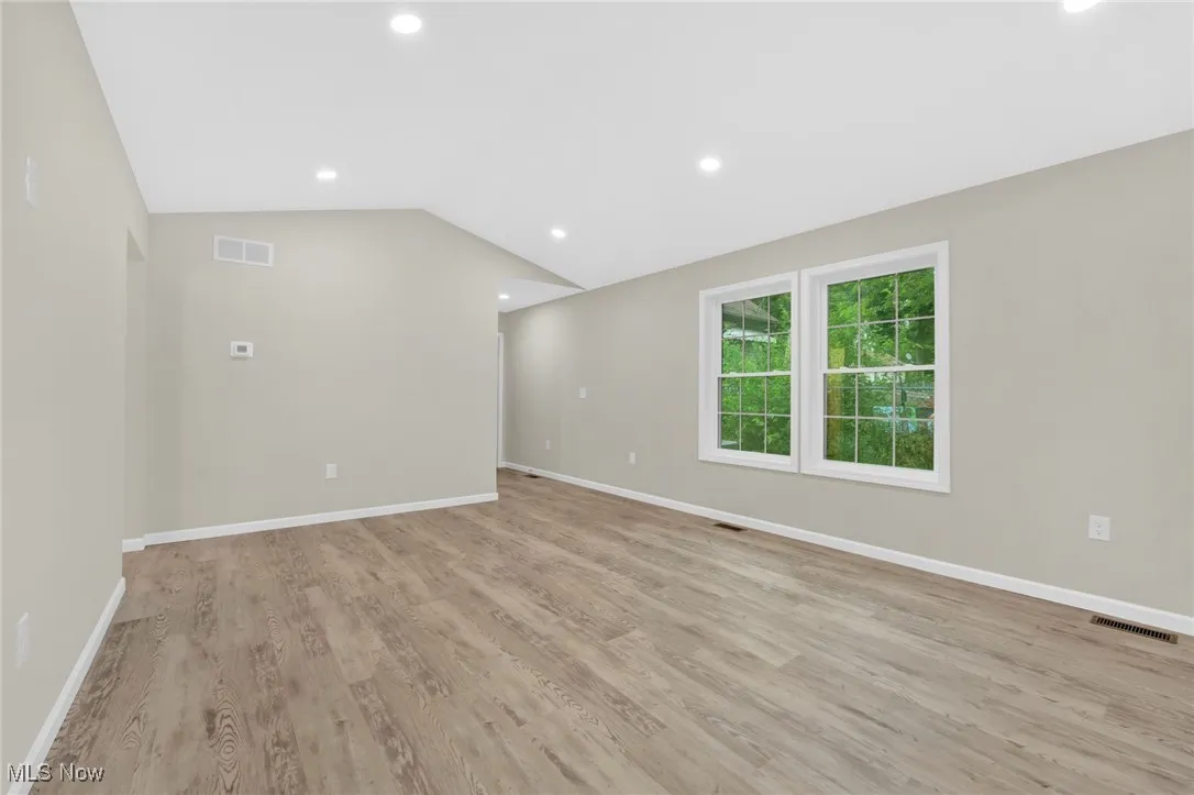 Spare room with light wood-type flooring, recessed lighting, and vaulted ceiling