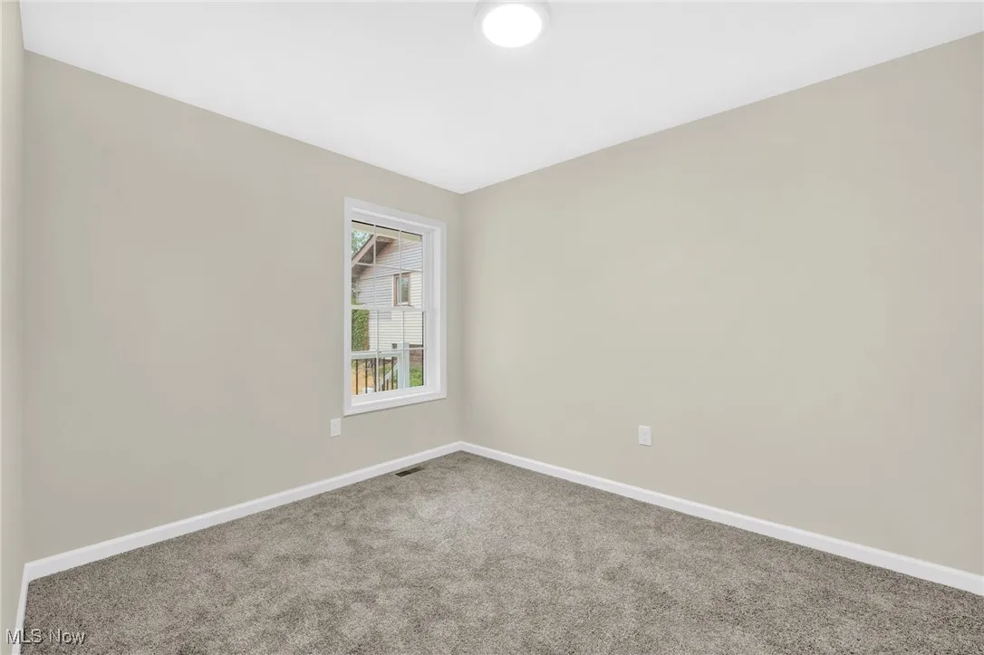 Empty room featuring carpet and baseboards