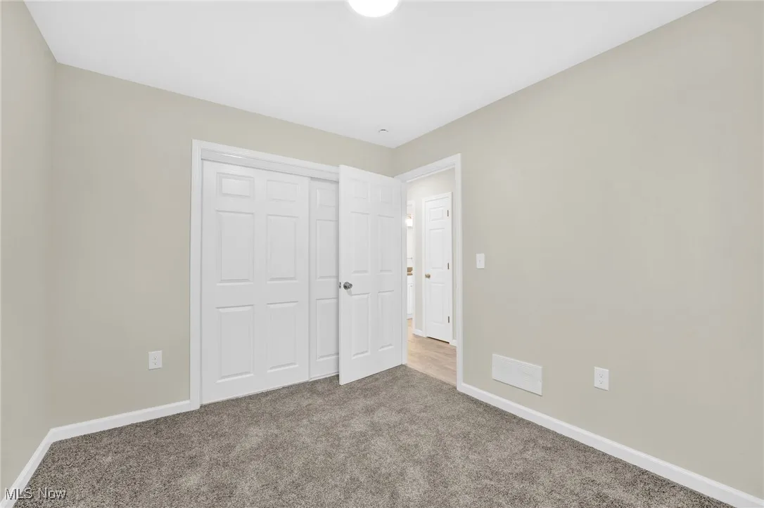 Unfurnished bedroom with carpet flooring and a closet