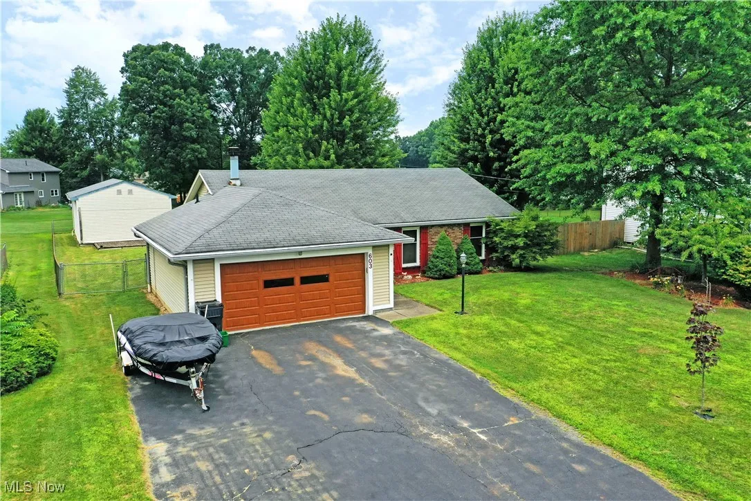 Single story home featuring driveway and a shingled roof
