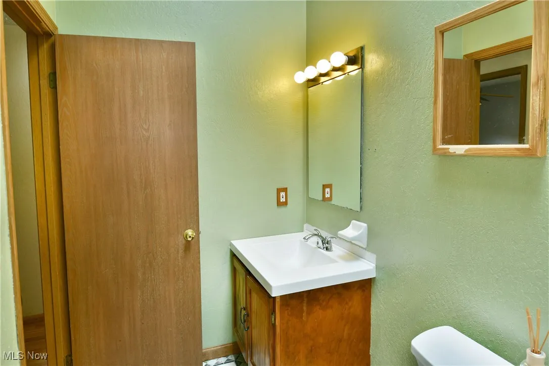 Half bathroom with vanity and a textured wall