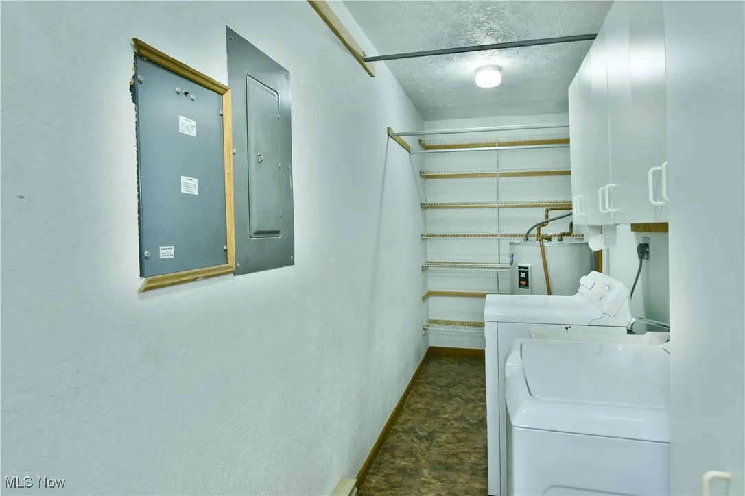 Washroom with washer and dryer, electric panel, and water heater