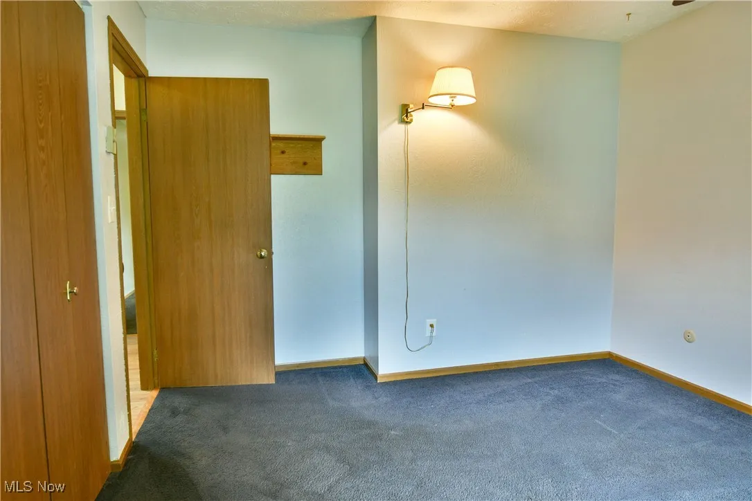 Carpeted empty room featuring baseboards