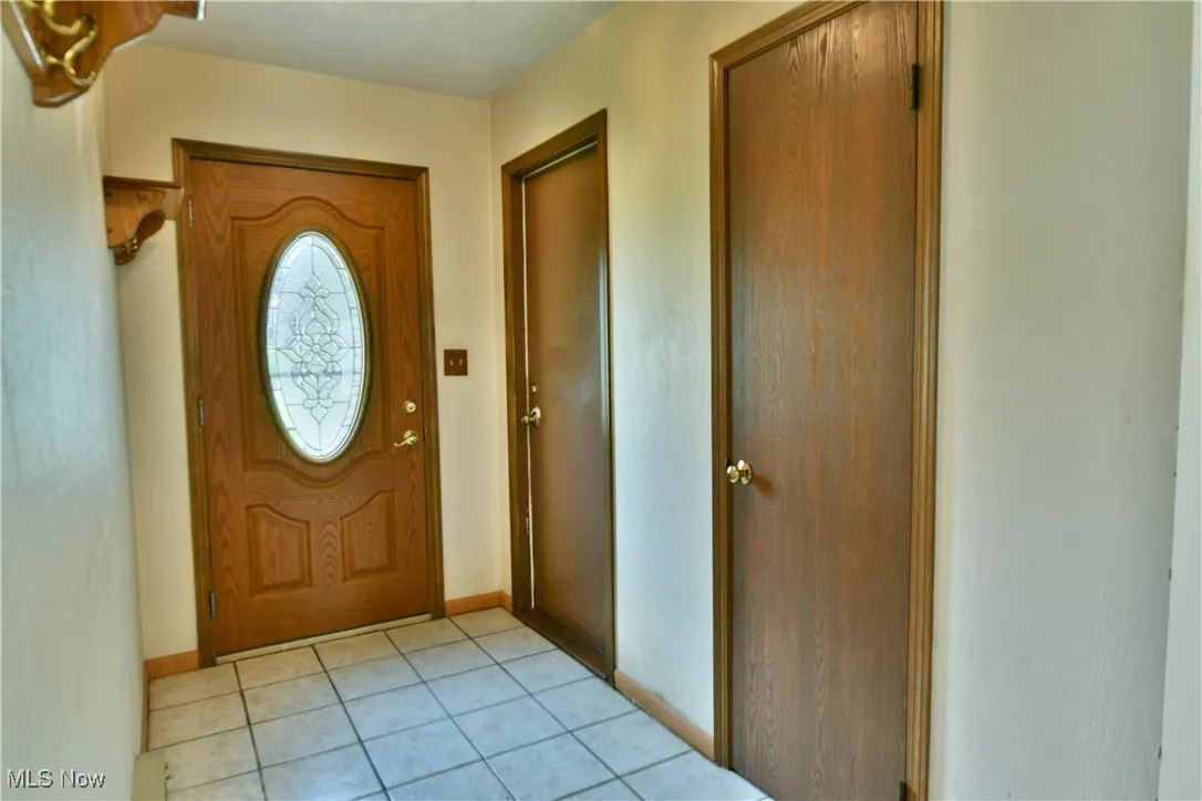 Entryway with baseboards and light tile patterned floors