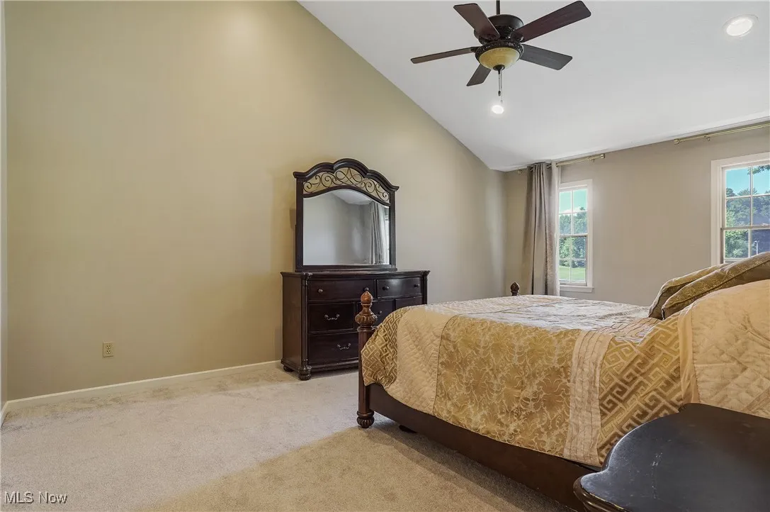 Bedroom with light carpet, recessed lighting, high vaulted ceiling, and a ceiling fan