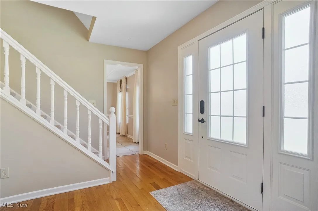 Foyer featuring stairway and light wood finished floors