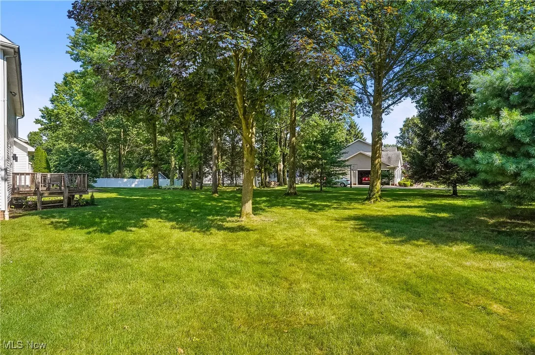 View of green lawn with a wooden deck
