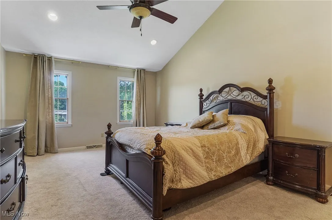 Bedroom featuring light colored carpet, lofted ceiling, recessed lighting, and ceiling fan
