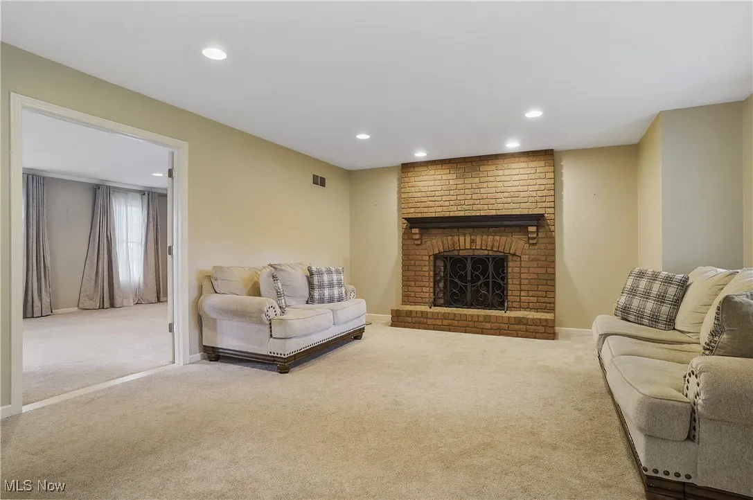 Carpeted living room featuring recessed lighting and a fireplace