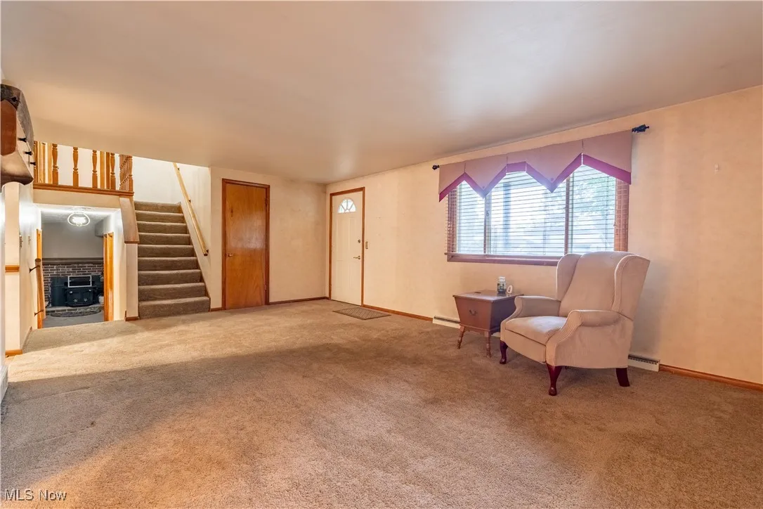 Living room with stairs up to 2nd floor and stairs down to lower level family room, 4th bedroom and full bathroom