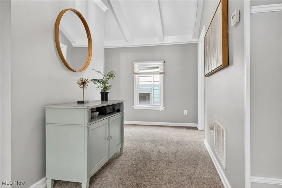 Corridor featuring light carpet and baseboards