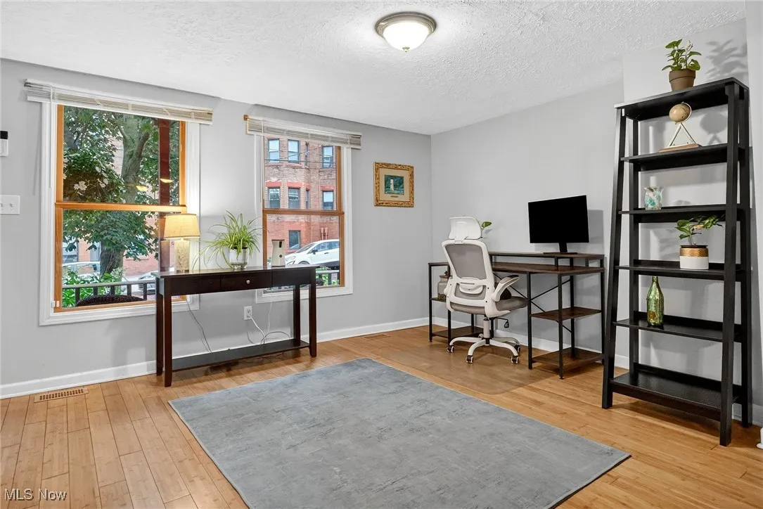 Office space featuring wood finished floors and a textured ceiling
