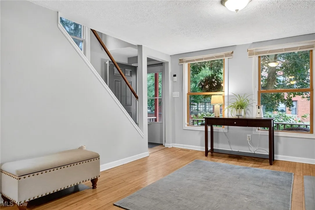 Foyer entrance with a textured ceiling, stairs, and wood finished floors