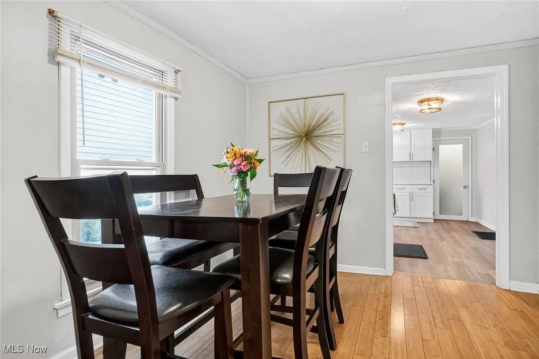 Dining room featuring light wood-type flooring and crown molding