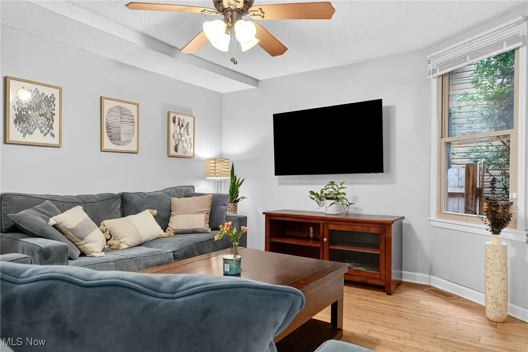 Living area with light wood-style floors and ceiling fan