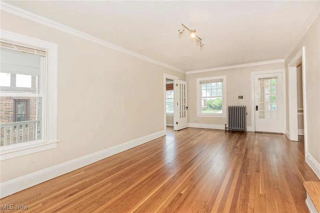 A view of the living room and door to foyer + window overlooking the back porch on the left.