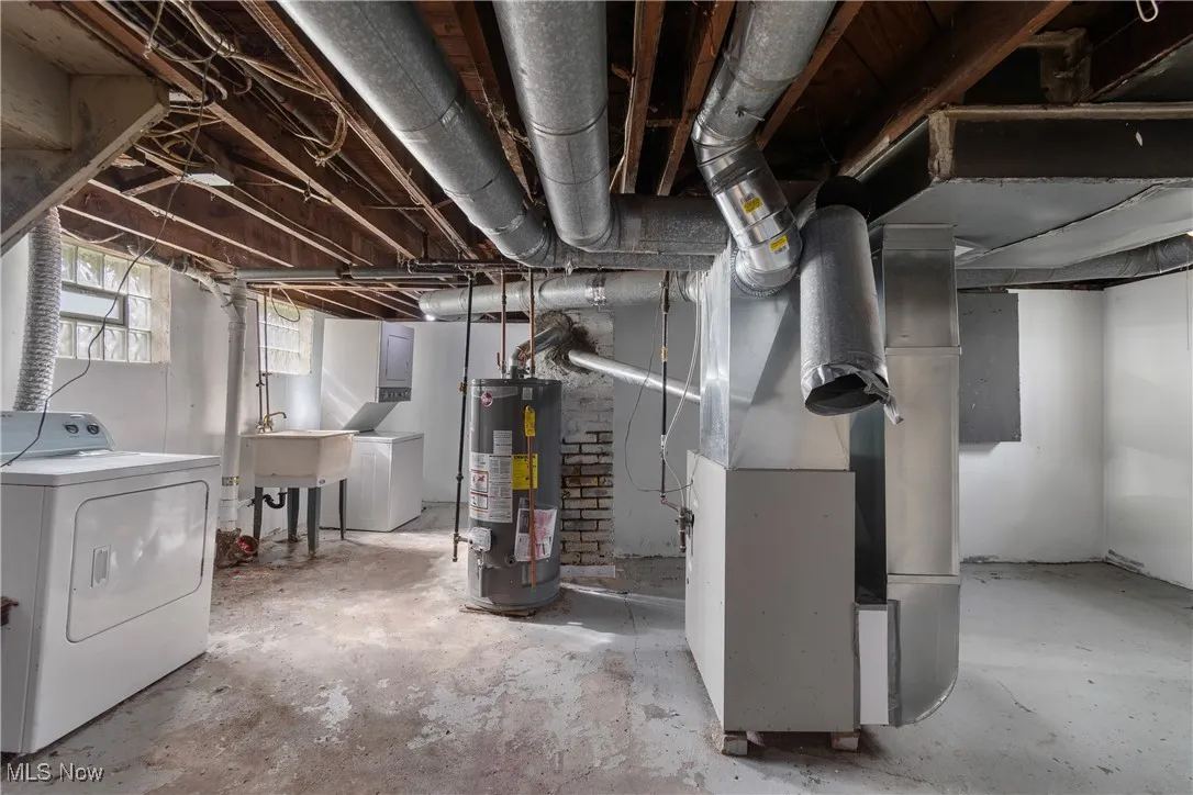 Below grade area featuring washer / clothes dryer, heating unit, and gas water heater