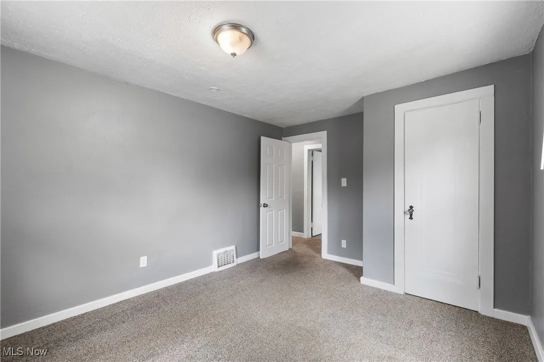 Unfurnished bedroom featuring carpet floors and a textured ceiling