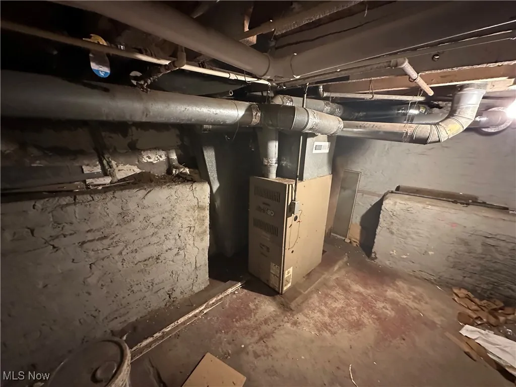 Unfinished below grade area featuring heating unit