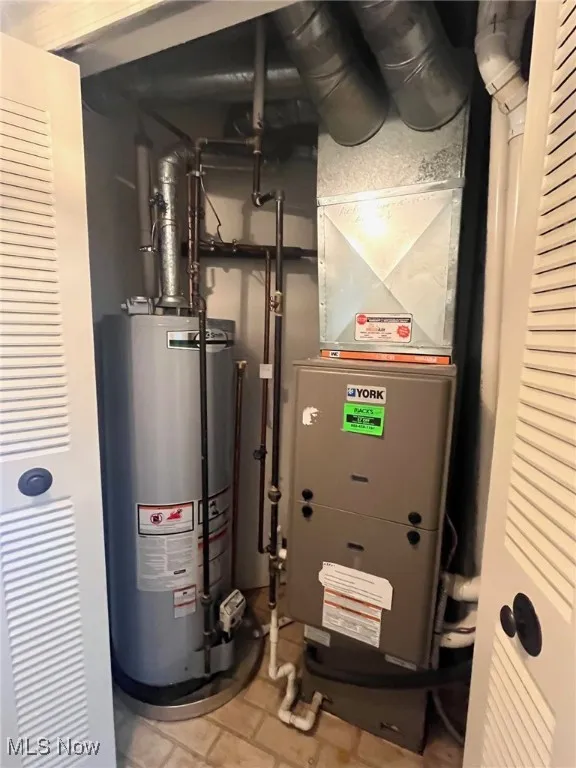Utilities closet with water heater and heating unit