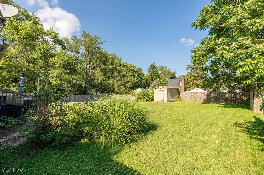 View of a fenced backyard with a shed.