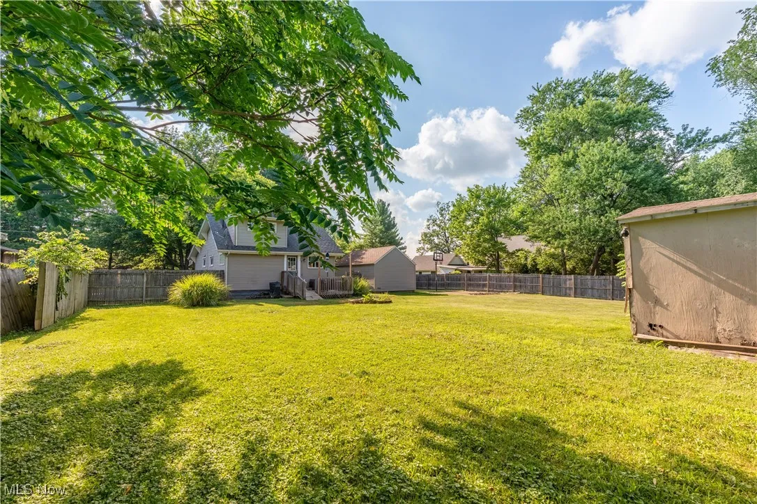View of fenced backyard with a shed.