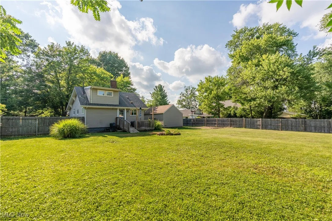 View of fenced backyard and rear of the home/deck.