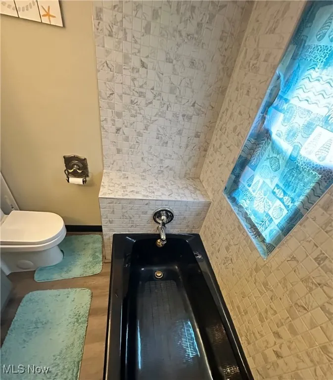 Bathroom with toilet and baseboards