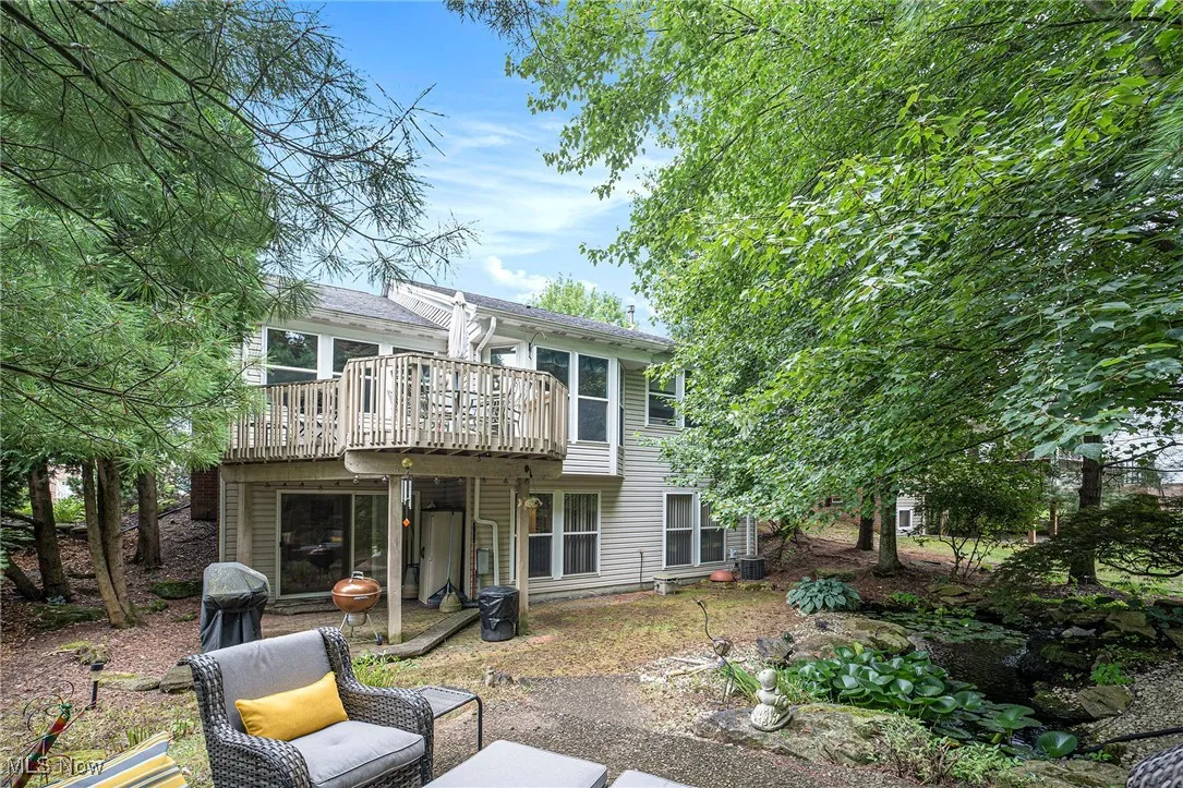 Back of property featuring a wooden deck and a patio