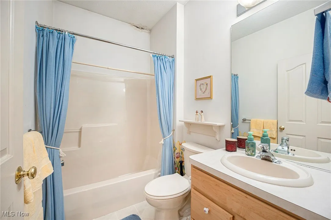 Bathroom featuring shower / tub combo, vanity, and tile patterned floors