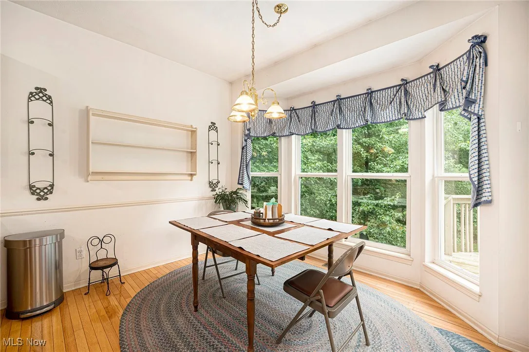 Dining area in kitchen featuring hardwood / wood-style flooring and a chandelier