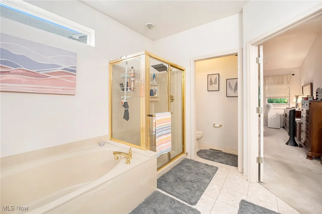 Bathroom featuring a shower stall, a garden tub, and tile patterned floors