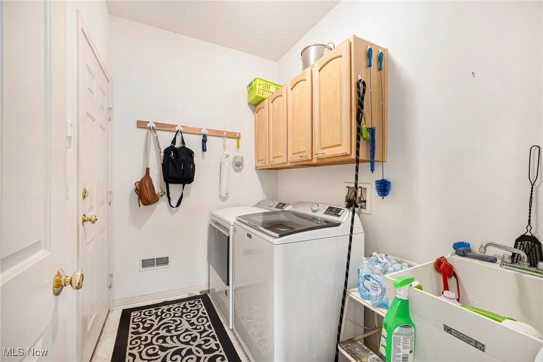Laundry room with washer and clothes dryer and cabinet space