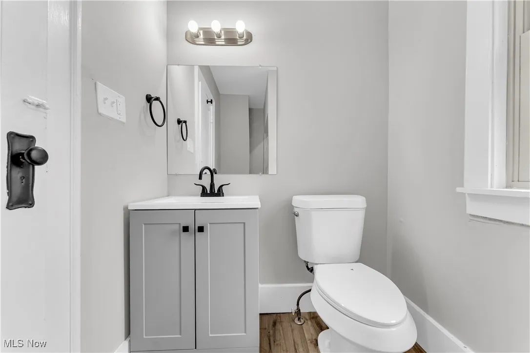 Half bath with vanity and wood finished floors