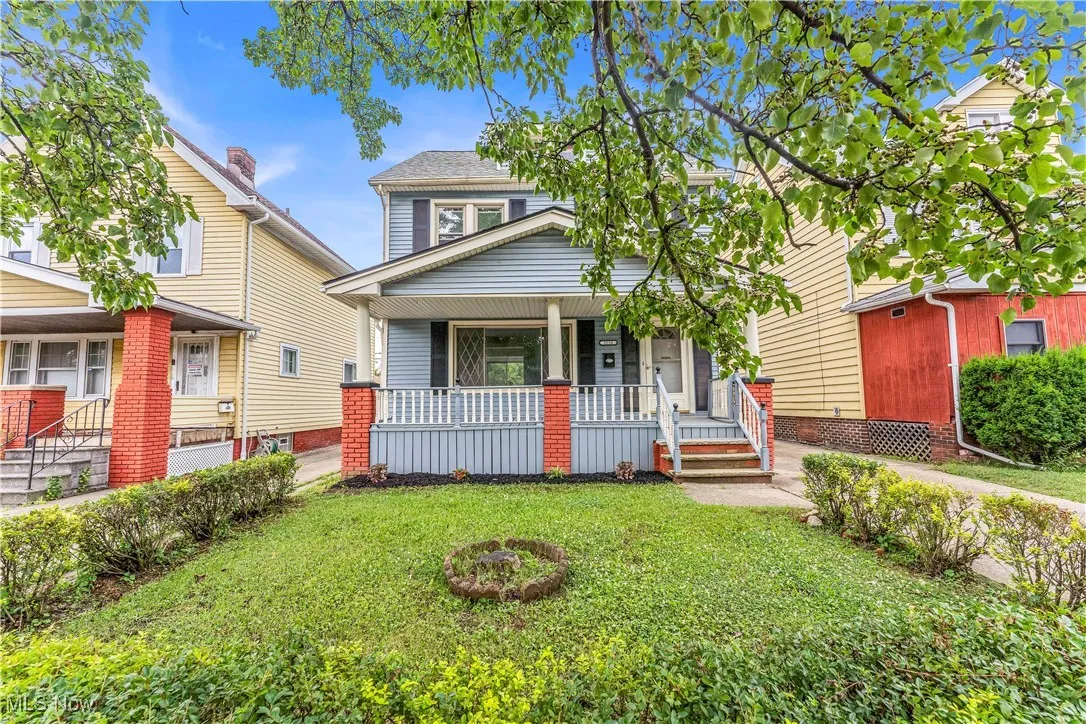 Traditional style home with covered porch and a front lawn