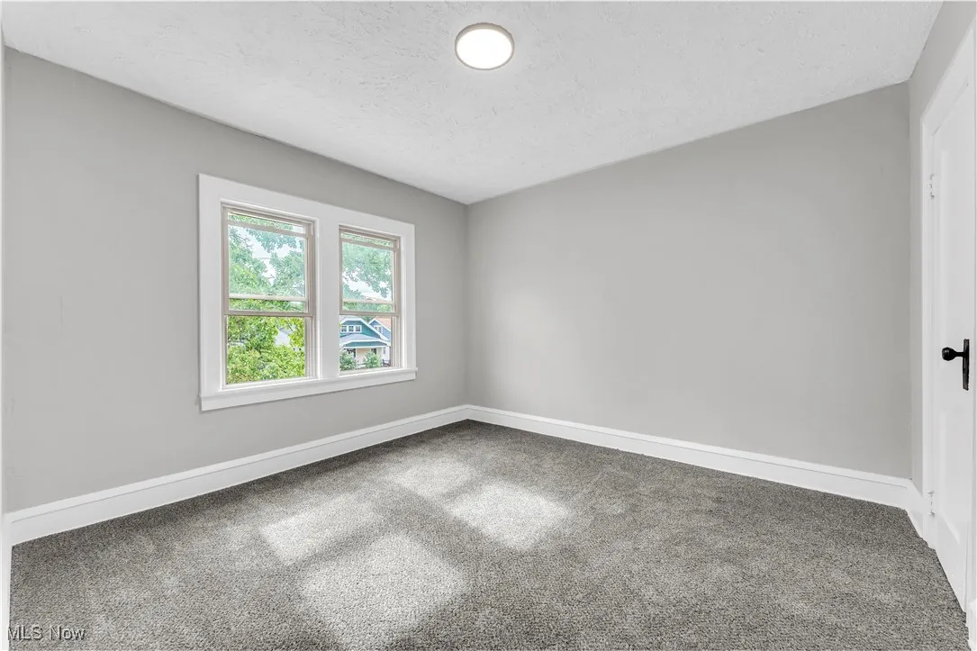 Unfurnished room with carpet and a textured ceiling