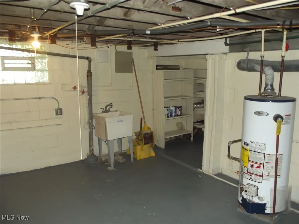 Basement featuring sink and gas water heater