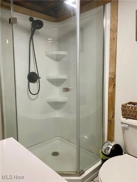 Full bath featuring a shower stall and toilet
