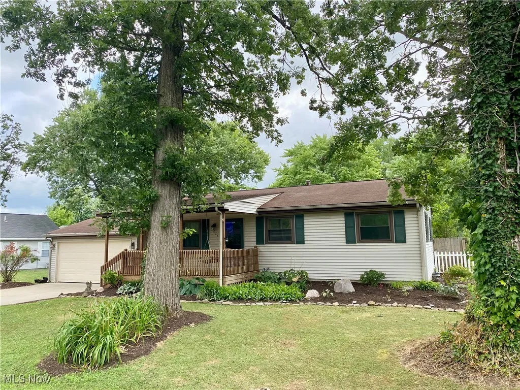 Single story home featuring a porch, driveway, and an attached garage