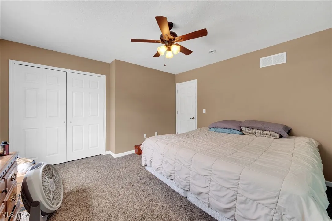 Bedroom featuring carpet floors, a closet, and a ceiling fan