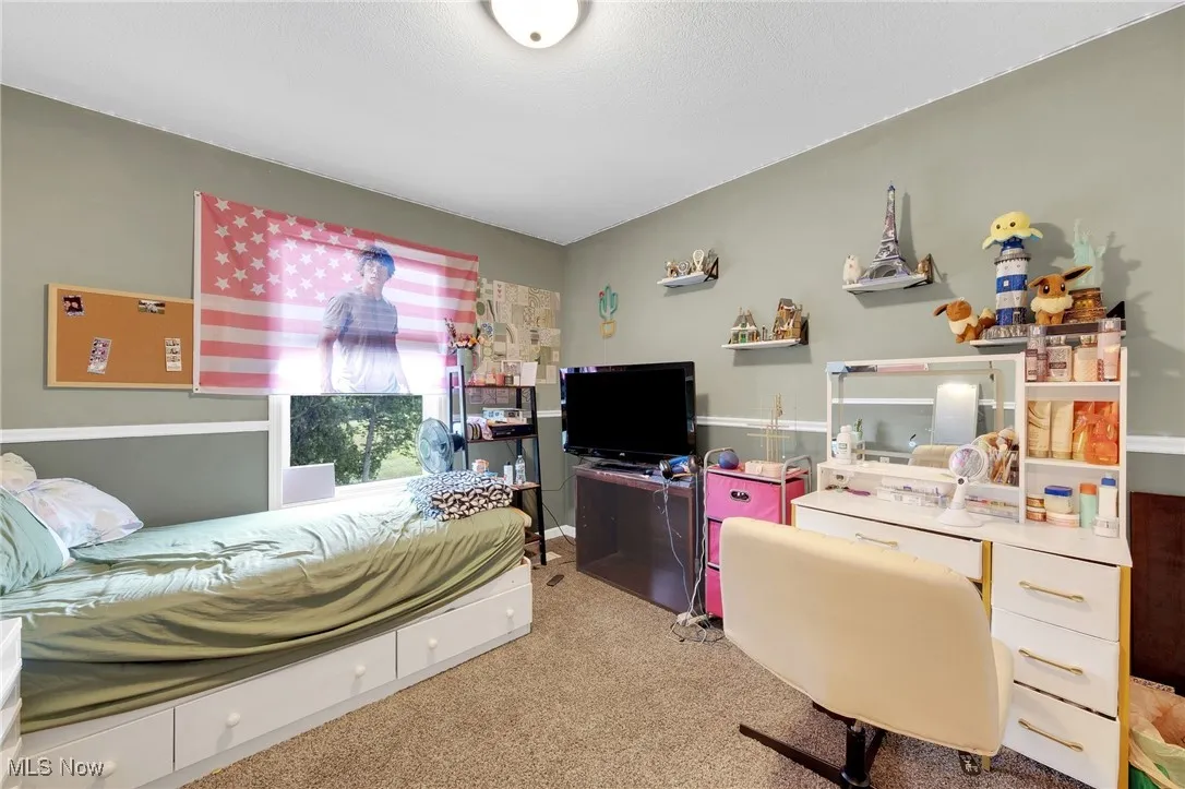 Carpeted bedroom featuring a desk