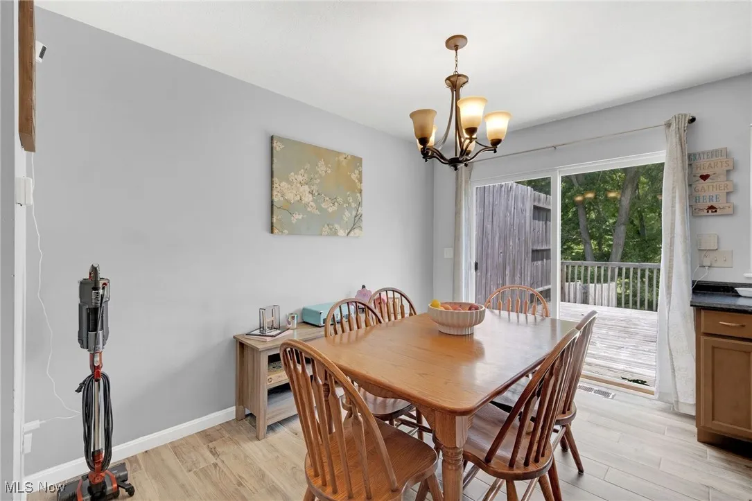Dining area with light wood finished floors and a chandelier