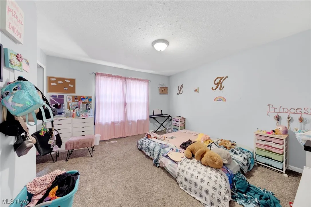 Carpeted bedroom with a textured ceiling