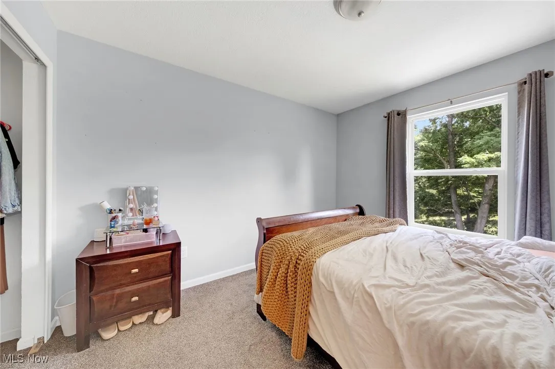 Bedroom featuring carpet and baseboards