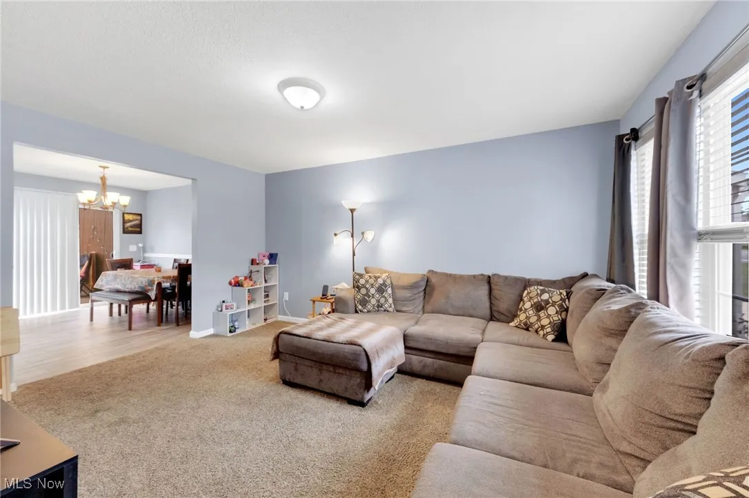 Carpeted living area with a chandelier