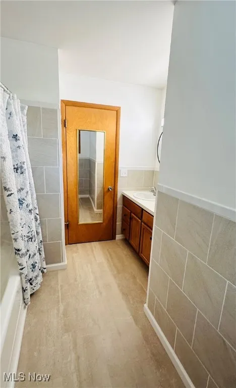 Full bath featuring vanity and shower / tub combo with curtain