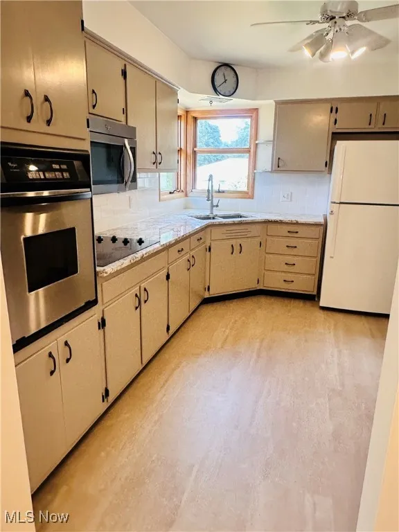 Kitchen featuring stainless steel appliances, backsplash, and a ceiling fan